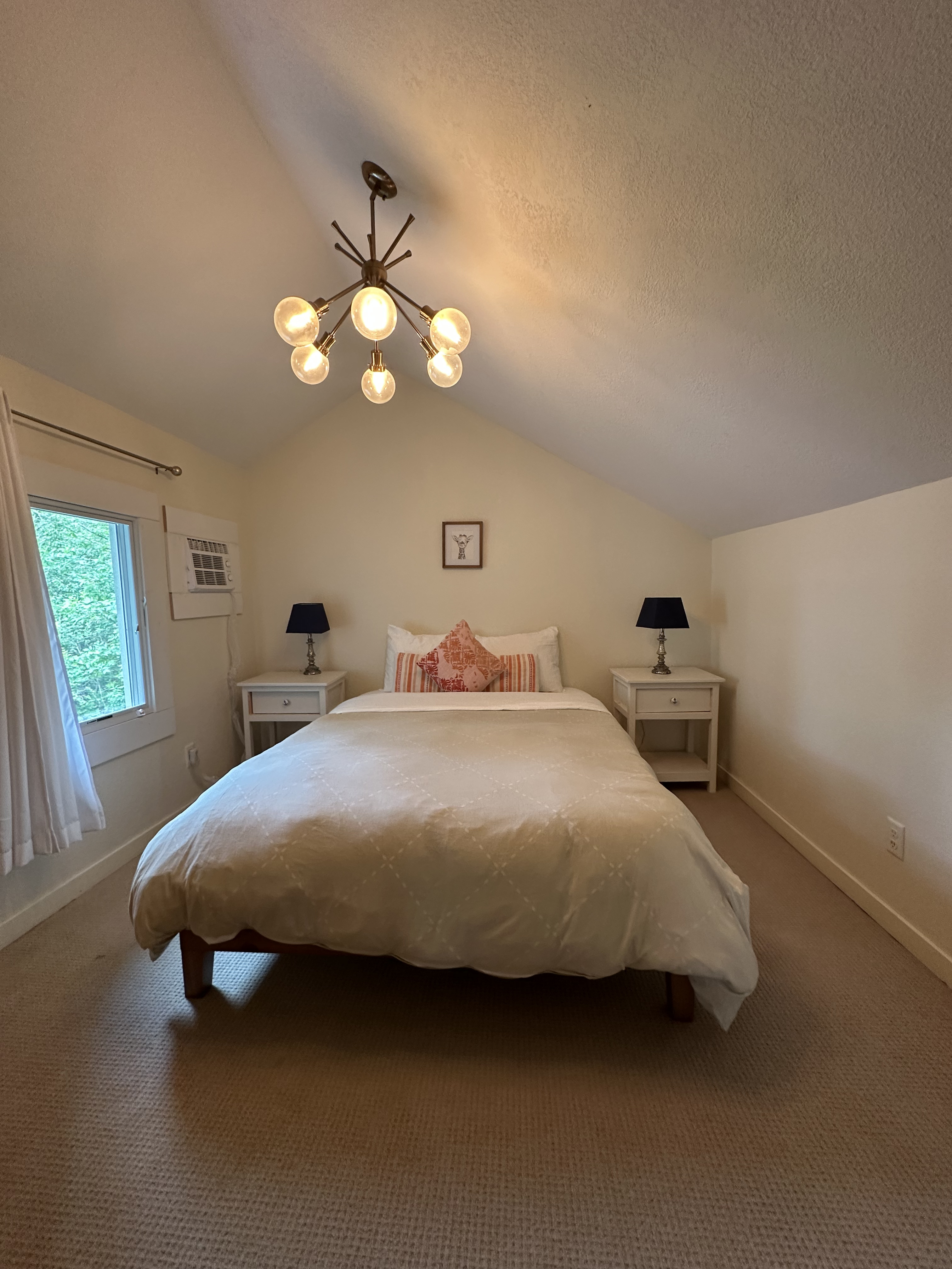 Clean guest bedroom with vaulted ceiling